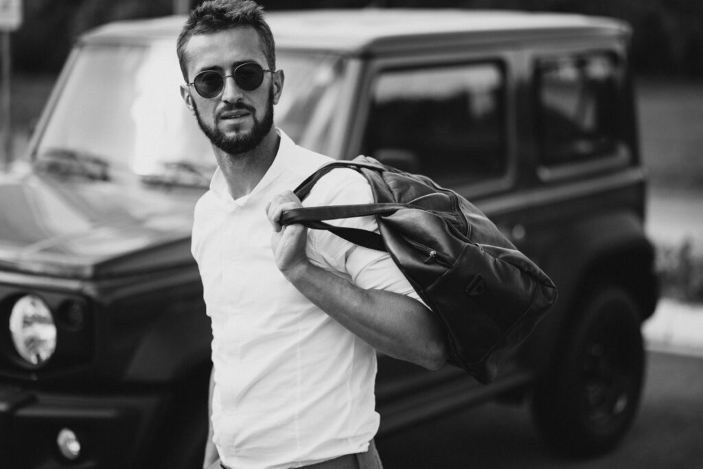 man travelling with bag and standing by the car man travelling with bag and standing by the car