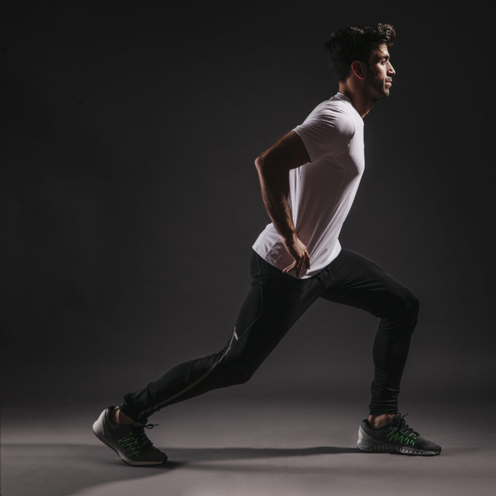 side view man lunging dark background